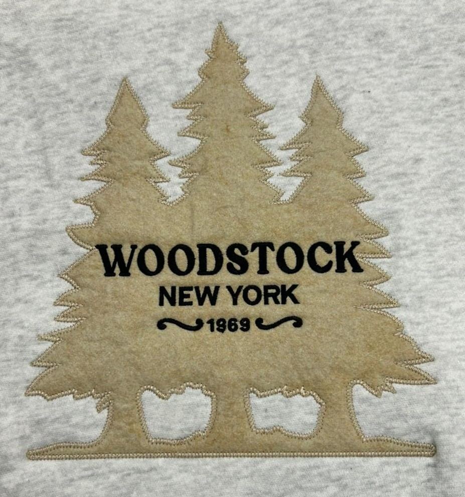 Single layer felt applique of pine trees reading Woodstock New York 1969